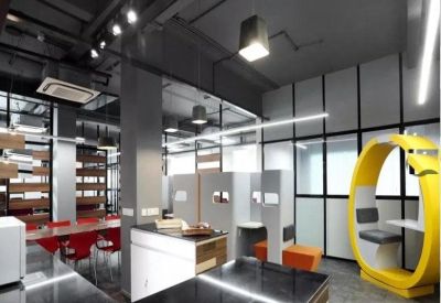 Modern communal breakout area featuring a yellow circular pod and sleek kitchen island.