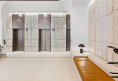 Elegant building lobby with arched portals, indoor plants, and curved seating.