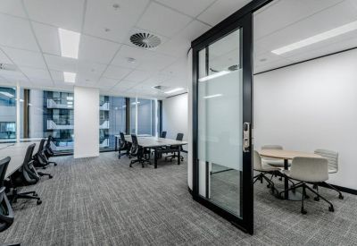Open plan workspace with glass partitioned meeting area.