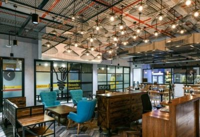 Reception area with a warm wooden front desk and a ceiling filled with numerous industrial light bulbs.