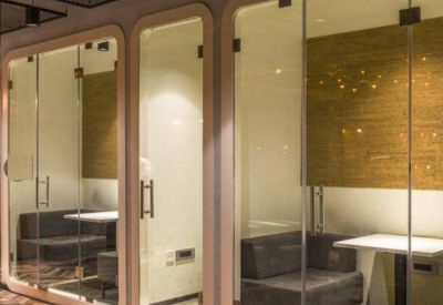 Private glass-enclosed phone booths or small meeting pods with grey seating.