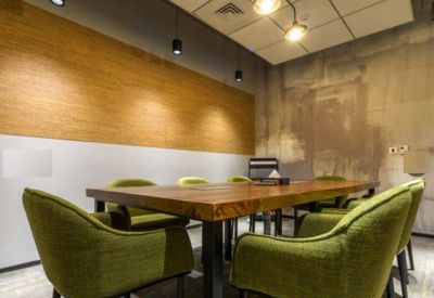 Boardroom with a wooden table and vibrant lime green upholstered chairs.