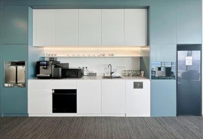 Modern kitchen area with coffee machine and microwave.