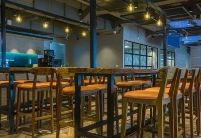 Café-style communal area with high-top wooden tables and warm pendant lighting.