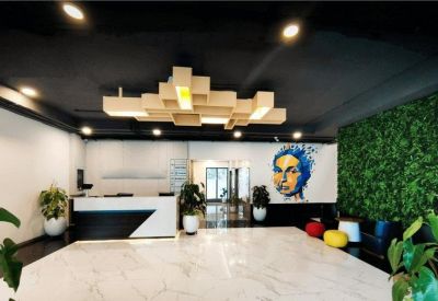 Modern reception area with a geometric wooden ceiling installation and mural.