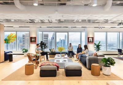 Bright lounge area with comfortable sofas and city views through large windows.