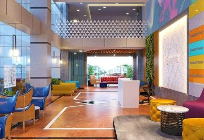 Spacious lobby with vibrant blue and yellow lounge seating and a vertical green wall.
