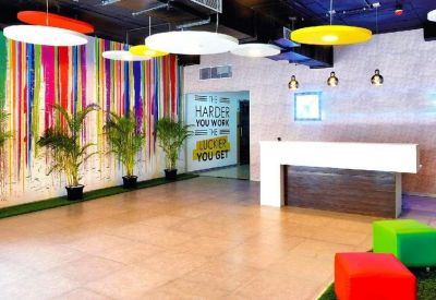 Modern reception area featuring a colorful drip-paint accent wall and stylish pendant lighting.