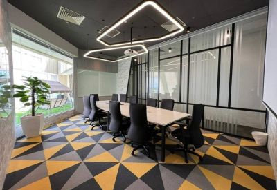 Spacious boardroom with a long table and geometric patterned carpet.