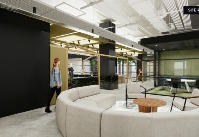 Breakout area with a curved white sofa and stylish wooden tables.