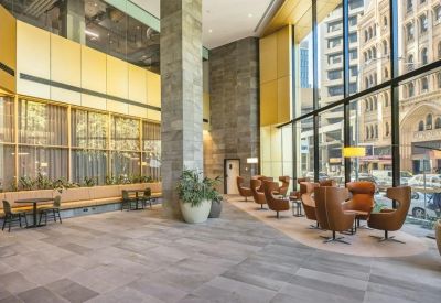 Spacious lobby with stone pillars and warm leather lounge seating.