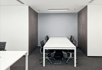 Meeting room with a white conference table and ergonomic black chairs.