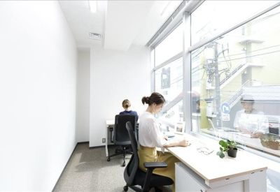 Sunlit workspace with a long desk positioned next to a large window.