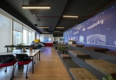 Modern coworking area with tiered wooden seating and a purple creativity mural.