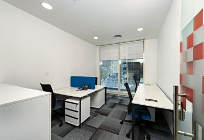 Private two-desk office with white furniture and patterned glass door.