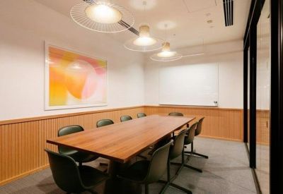 Professional meeting room with a large wooden table and modern pendant lighting.