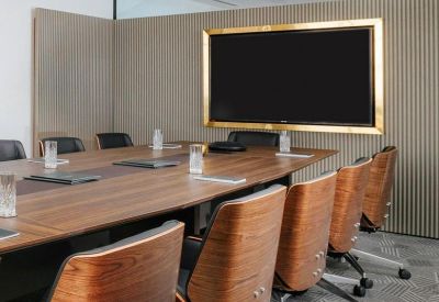 Modern boardroom featuring a wood-topped table and ergonomic mid-century style chairs.