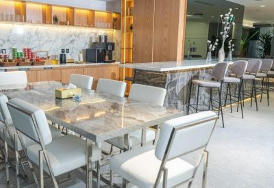 Modern kitchen and break area with marble dining tables and breakfast bar.