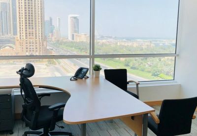 Bright private office with an L-shaped desk and ergonomic chair by the window.