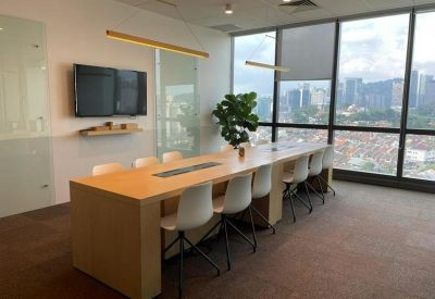 Shared workspace with a long wooden table, white chairs, and views of the city skyline.