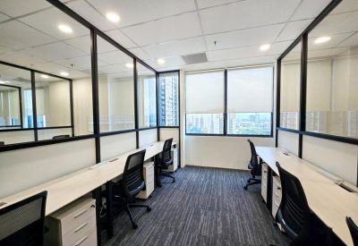 Internal office suite with white desks, black chairs, and large windows with city views.