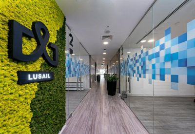 Hallway featuring a green moss wall with corporate branding and glass office partitions.