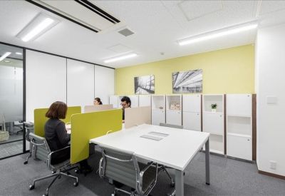 Coworking space with shared desks, lime green dividers, and built-in storage.