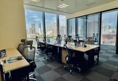 Open coworking space with large windows overlooking the city and checkered carpet.