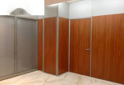Private office suite with warm wood wall paneling and a matching door.