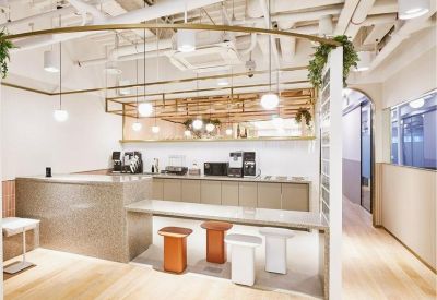 Sleek coffee bar area with stools and overhead designer lighting.