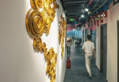Hallway with large golden spiral wall art and office entrance.