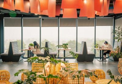 Spacious breakout area featuring booth seating, wicker chairs, and floor-to-ceiling windows.