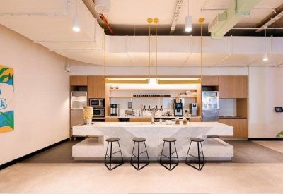 Modern office kitchen and refreshment bar with marble island and stylish stools.
