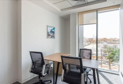 Two-person private office suite with natural light from a large window overlooking the city.