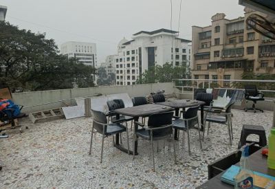 Outdoor terrace communal area with dining tables, chairs, and views of surrounding buildings.