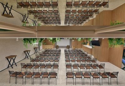 Large event space or auditorium with rows of seating and mirrored ceiling panels.