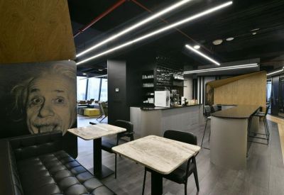 Modern café area with stone-top tables and a mural of Albert Einstein.