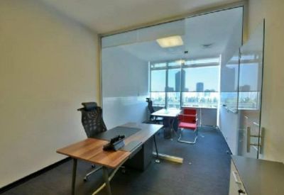 Private executive office with a wooden desk, leather chair, and panoramic city views.