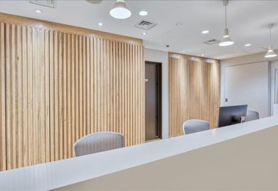 Sleek reception desk with wood slat wall and modern pendant lighting.