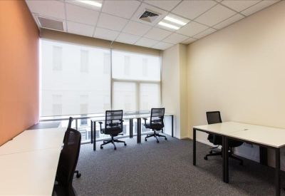 Bright private office suite with white desks and mesh chairs by a large window.