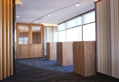 Modern hallway with wooden podiums, striped wallpaper, and large windows.