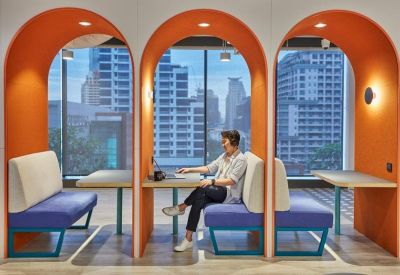 Orange arched work pods with purple seating and city backdrop.