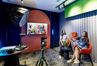 Modern media studio with cameras, lighting, and a green screen.