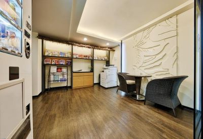 Relaxed seating area with wicker chairs and a textured feature wall.