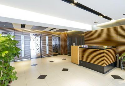 Modern lobby with a wood-slatted reception desk and elevator bank.