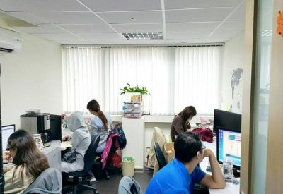 Operational shared office space with staff working at computer workstations.