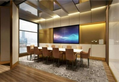 Elegant meeting room with a long white table, leather chairs, and a large digital screen.