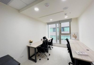 Private office featuring two workstations and a large window providing natural light.