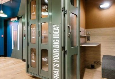 Private green phone booth for calls with text reading What's your big idea on the glass door.