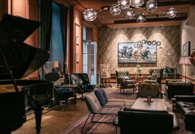 Spacious communal lounge featuring a grand piano, eclectic seating, and a large painting.